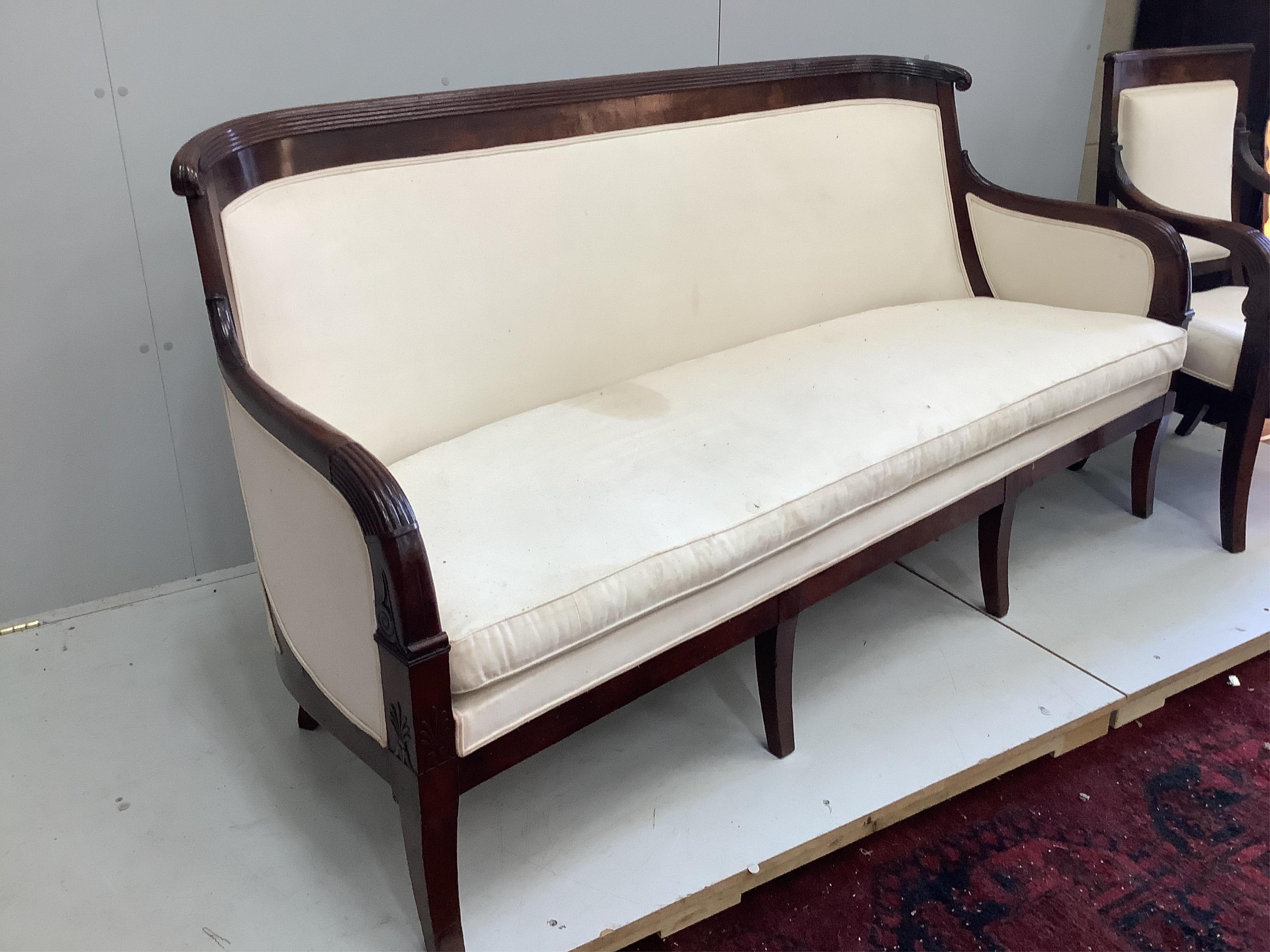 A French Empire upholstered mahogany settee, width 176cm, depth 60cm, height 92cm and a similar fauteuil. Condition - good